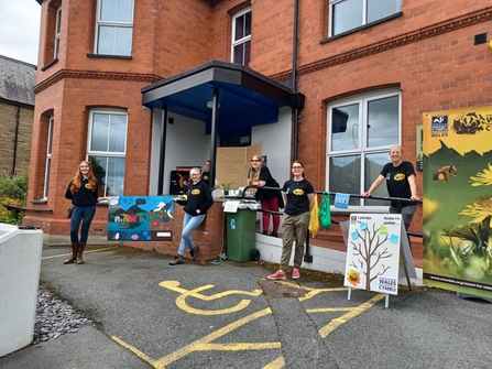 Young people stood in front of a red building with climate change posters